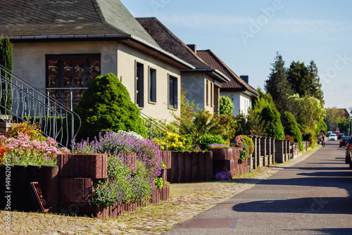 Wallpaper Mural City street of single-family modern houses Germany blooming flowers bed  green bush hedge. German suburban small town residential area row eco sustainable life building neighborhood suburb Torontodigital.ca