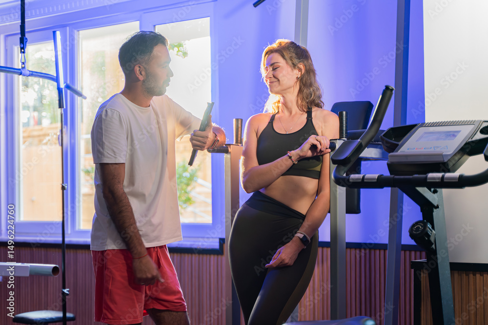 Obraz premium Couple working out in home gym, Personal trainer assisting client