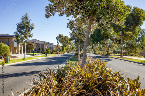 Modern suburban street in Point Cook, Melbourne Australia featuring landscaped road median, contemporary houses, and native trees. Concept of urban planning, residential living and infrastructure photo