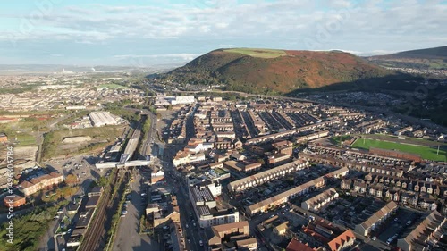 Sunny morning in town. Aerial footage of rows of houses along streets in urban neighbourhood. Port Talbot, Wales, UK