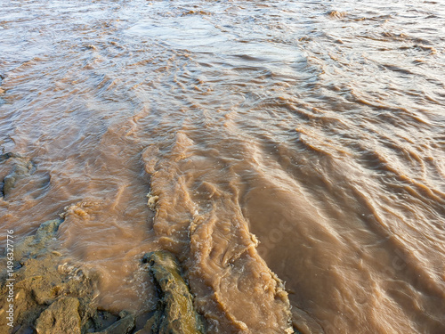Obraz na plátně murky brown river water flows through natural rocks