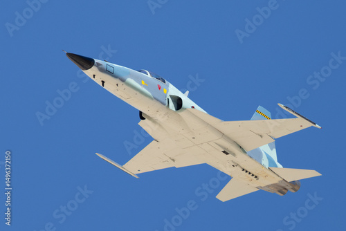 bottom view  of a F-5E Tiger II in the aggressor color scheme, approaching in beautiful light