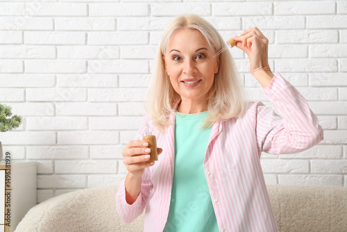 Mature woman with bottle of...