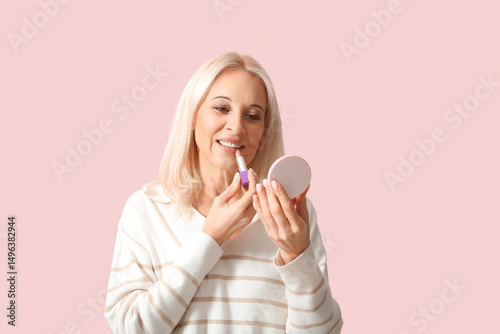 Mature woman applying lipst...