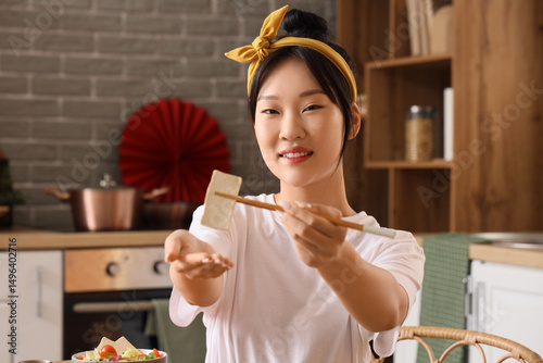 Young Asian woman eating ta...