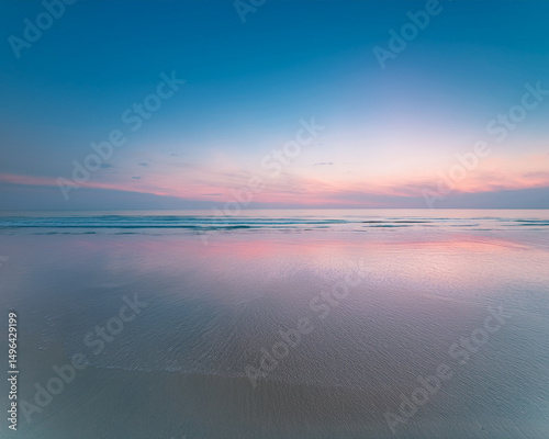 A  calm beach at dusk, soft pastel colours in the sky and water