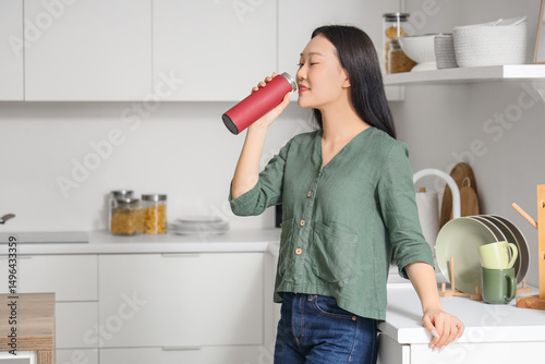 Young Asian woman drinking ...