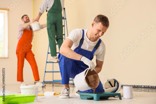 Male decorator pouring pain...