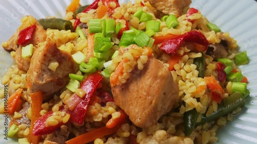 Bulgur with stewed meat and vegetables in green onion sauce rotating in a circle