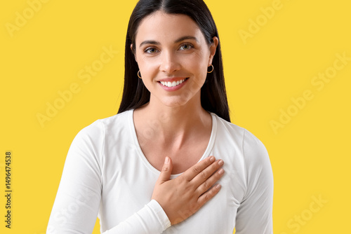 Thankful young woman on yel...