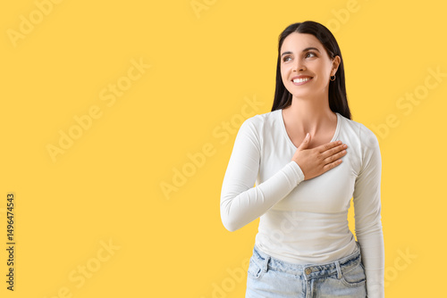 Thankful young woman on yel...