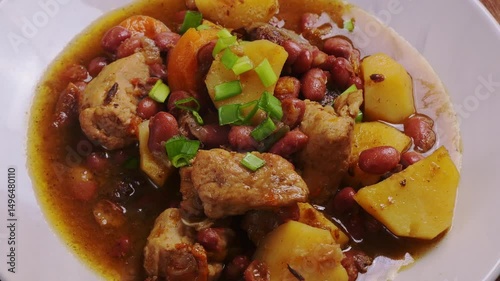 Chelnt with meat, potatoes and beans in a plate, rotating in a circle