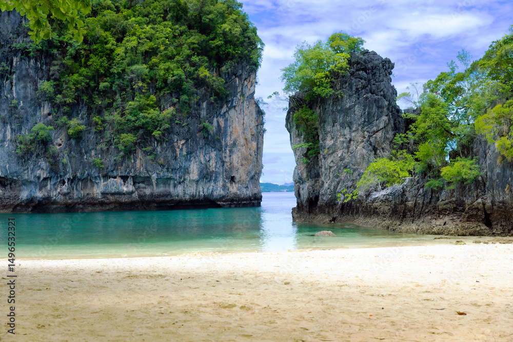 Obraz premium Stunning tropical beach on Hong Island in Krabi Province, Thailand. Surrounded by emerald waters, dramatic limestone cliffs, Ideal for tropical beach pictures, beach screensavers