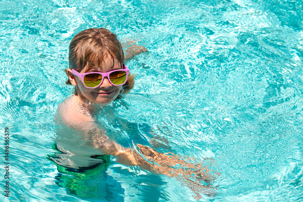 Naklejka premium Summer kids vacation, boy swim in pool. Child in swimming pool. Summer activity. Healthy kids lifestyle.