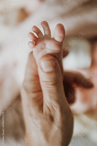 baby's spread toes in parent's hand