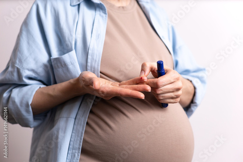 Health. Medicine. Gestational diabetes mellitus. Disease. A pregnant woman does a blood test from a finger for glucose. White background. Space for text