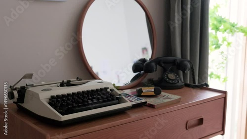 A retro typewriter and film camera on the table. And an old telephone. A classic and retro interior.