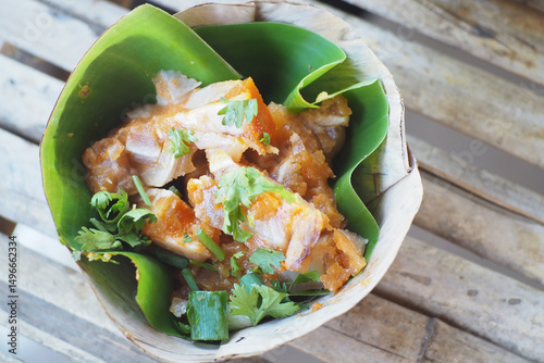 A delicious plate of flavorful food wrapped in green leaves, showcasing vibrant colors and fresh ingredients. photo