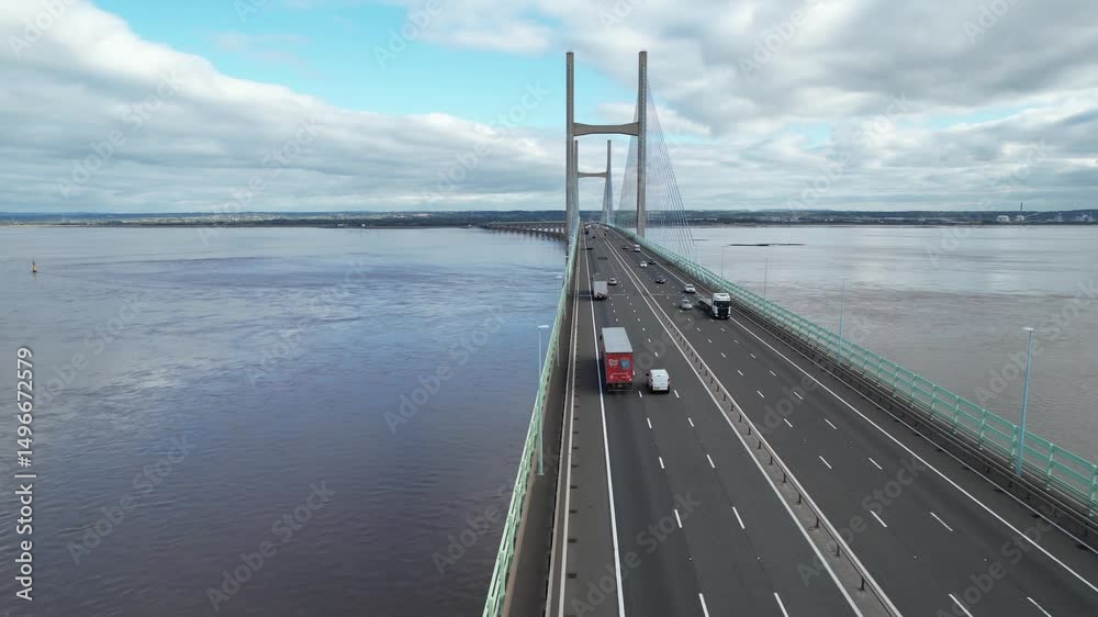 Traffic on long and high multilane road bridge over wide river estuary. Fly over bridge deck. Prince of Wales Bridge, Wales, UK
