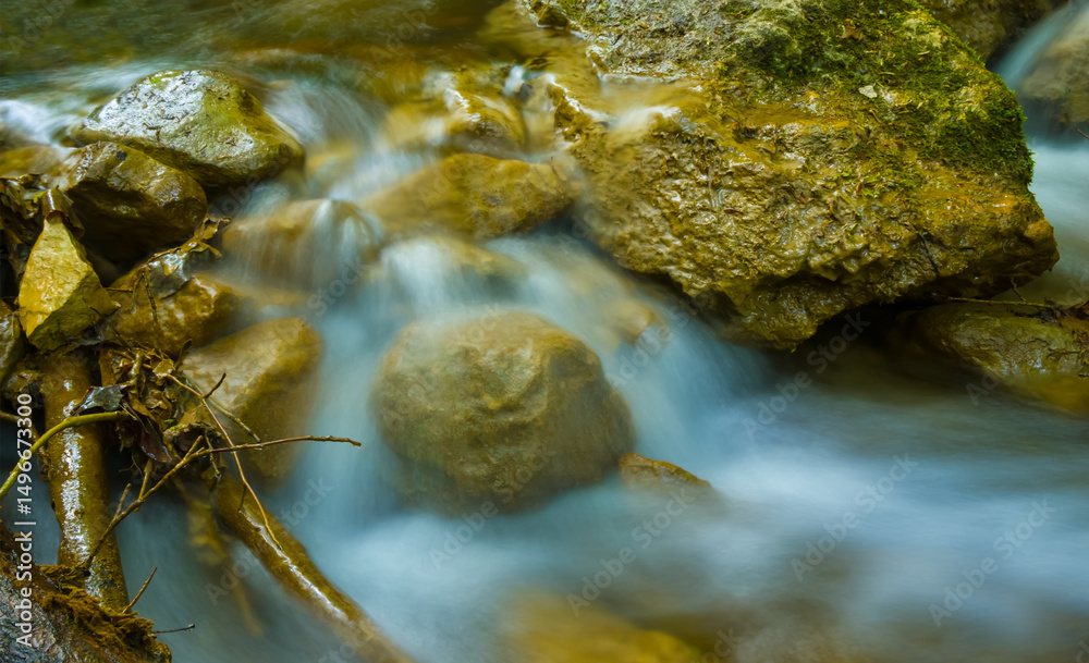 Obraz premium small mountain brook rushing over a stones in mountain canyon