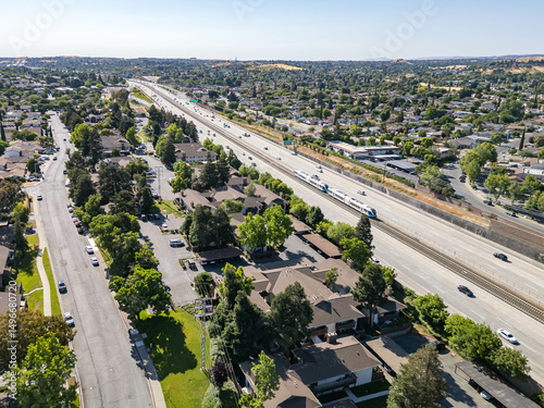 Aerial view of residential apartment complexes adjacent to Highway 4 with surrounding neighborhoods and the rolling hills of Antioch in the distance. photo