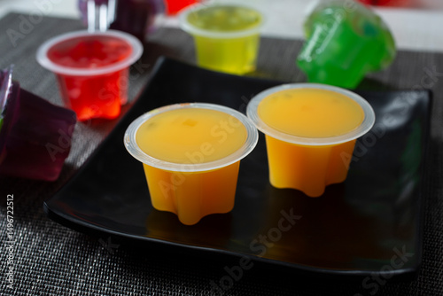 A view of some mango flavored fruit jelly cups, on a plate.
