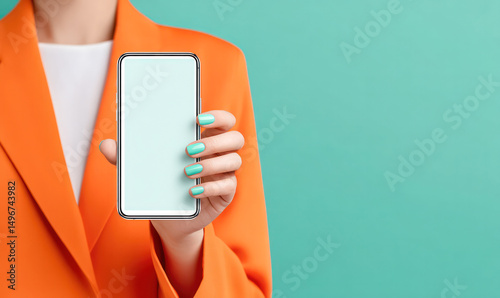 Young woman in an orange suit showing smart phone with white screen.
