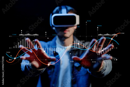 Young man wearing virtual reality headset interacting with digital data visualizations against a dark background in a modern technological environment