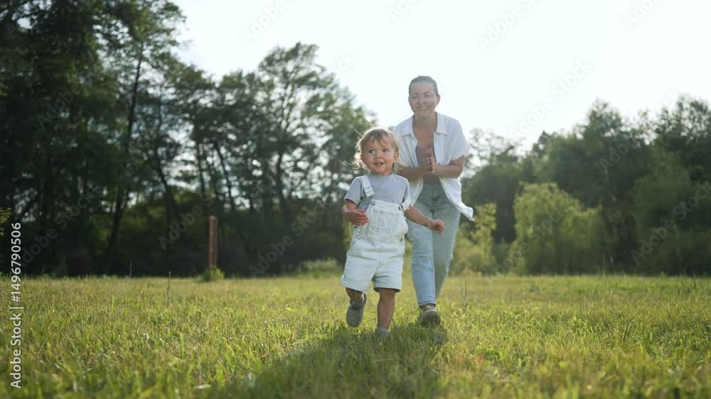 Happy toddler first step outside. Toddler taking first step with family. Joyful family moment outdoors. Mother watching child step forward. Scenic family walk in nature. Family step into adventure.