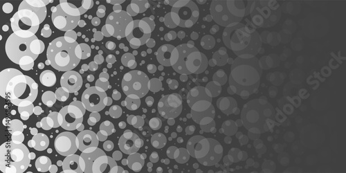A monochromatic abstract pattern of overlapping circles with varying sizes and opacity, forming a textured and dynamic design on a dark background.