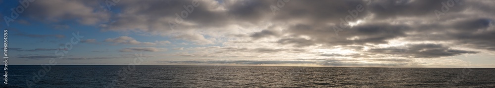 Fototapeta premium A cloudy sky with a calm ocean in the background