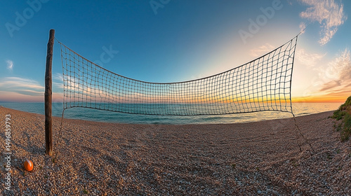 Solitary beach volleyball net silhouetted against a vibrant sunset seascape