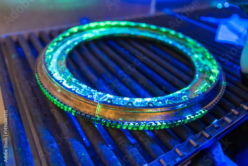 A high-precision aerospace component is undergoing fluorescent penetrant testing with distinctive green indications. Non-destructive evaluation exposes  discontinuities in this critical flight safety 