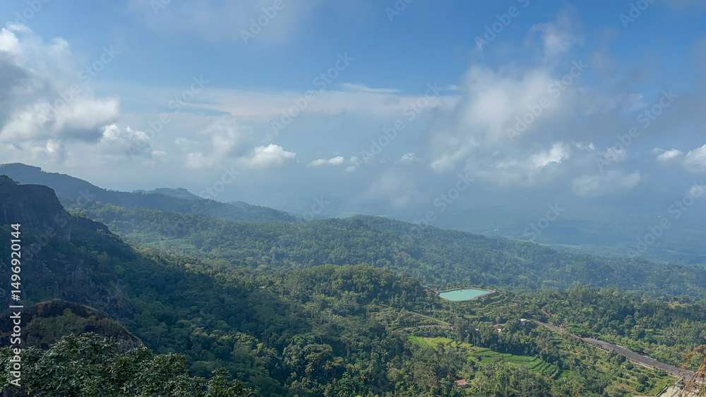 Fototapeta premium Breathtaking Panoramic View of Lush Green Mountains and Serene Lake Under a Cloudy Sky