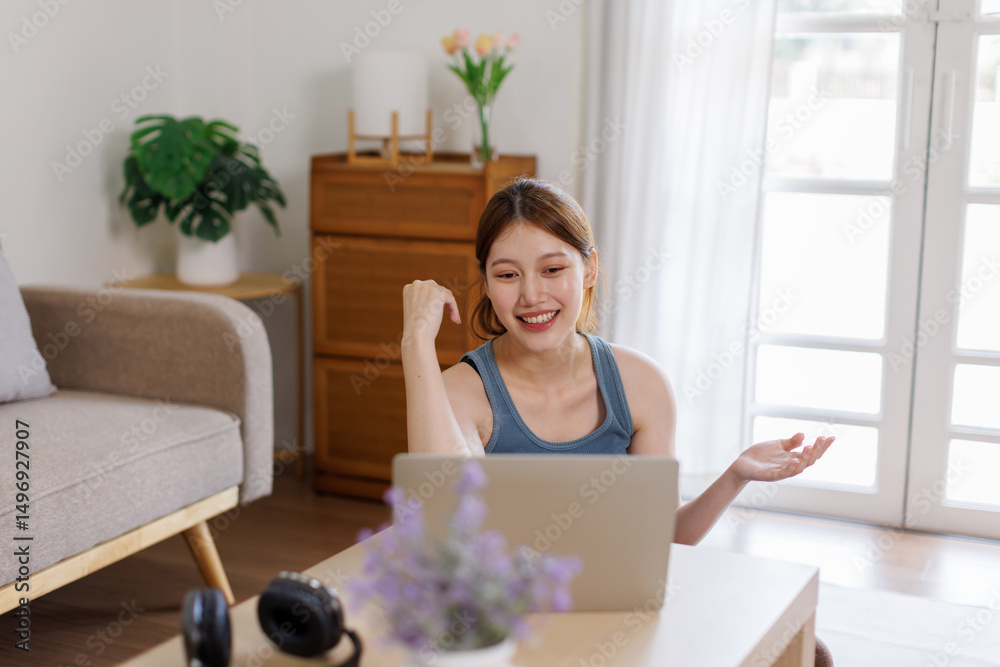 Image of cheerful asian woman using laptop while sitting at home in living room
Image of cheerful asian woman using laptop while sitting at home in living room