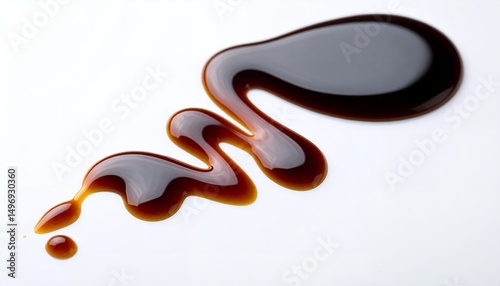 Close-up of a glossy, dark brown balsamic glaze drizzled and swirled artistically on a pristine white surface, creating an elegant food photography composition.