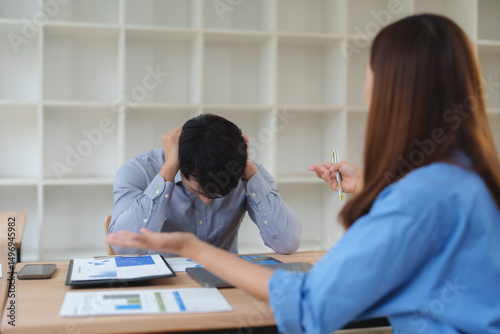 Businesswoman scolding businessman for bad work results in office meeting