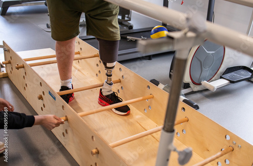Man with prosthetic leg in gym. Amputation and use of an artificial leg. Training exercises to maintain health. Person with amputation.
