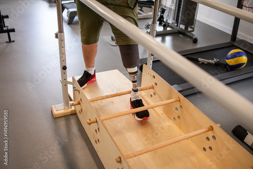 Man with prosthetic leg in gym. Amputation and use of an artificial leg. Training exercises to maintain health. Person with amputation.