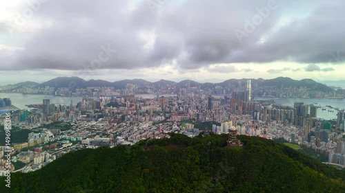 Cityscape view from mountain peak at dusk. Urban skyline meets nature with soft light and distant buildings fading into the twilight sky.
