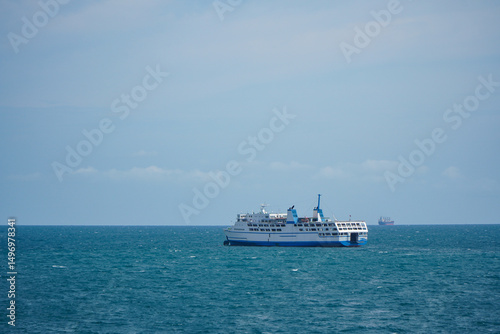 Ferry Vessel Navigating Calm Ocean Waters Under Clear Blue Sky with Distant Horizon photo