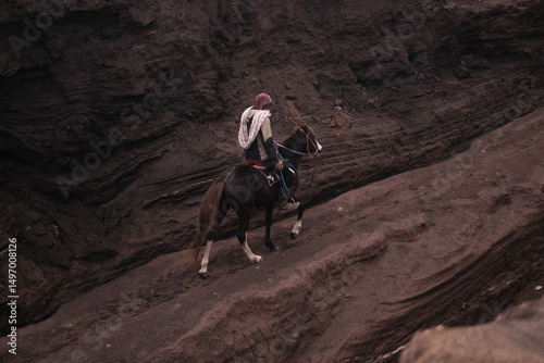 view of a person on horseback in a rocky, volcanic environment. Java, Indonesia - 19th March 2025