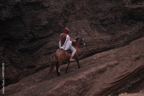 view of a person on horseback in a rocky, volcanic environment. Java, Indonesia - 19th March 2025