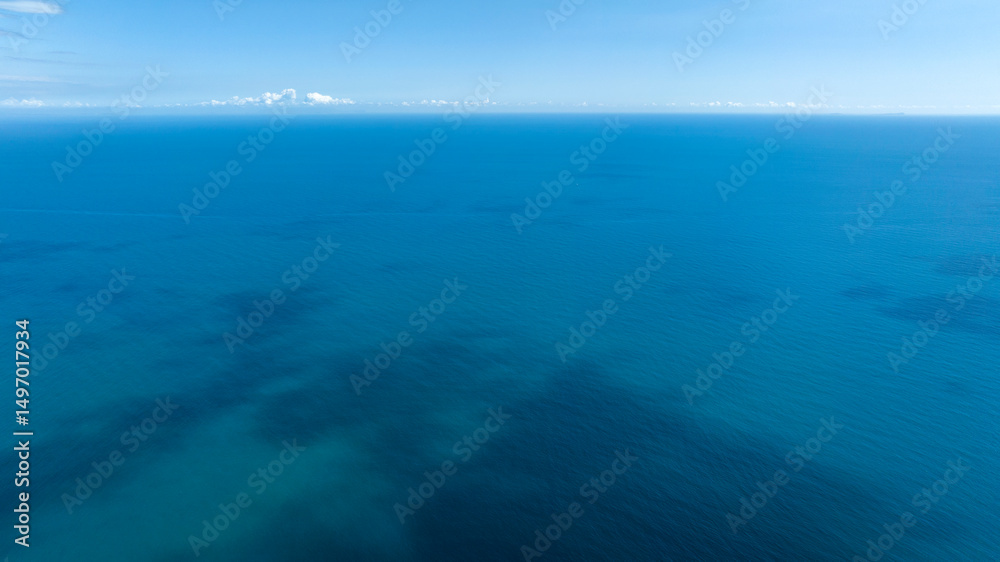 Obraz premium Aerial view of the blue sea. The surface of the water is calm and clean. There are no boats until the horizon.