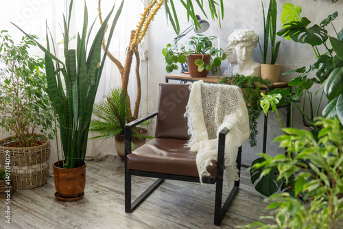 A fragment of the interior with a variety of indoor plants and plaster sculptures. Urban jungle concept. Biophilia design.