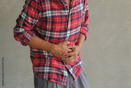 Asian man standing with severe stomach pain. Diarrhea. Emergency illness that requires hospitalization.