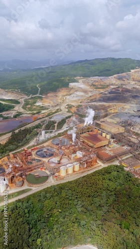 Extensive Barrick Gold open-pit mine in Cotui, industrial landscape of gold and silver extraction, Dominican Republic. Aerial forward, vertical format, copy space photo