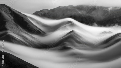 Black and white photograph of a mountainous landscape. the photograph is taken from a low angle, looking up at the mountains in the distance.