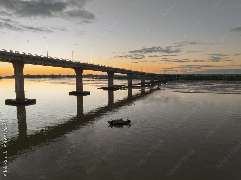 Fototapeta premium Cua Hoi bridge spans peaceful waters at sunset in Vinh city, Nghe An, Vietnam