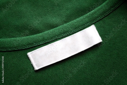 Blank White Clothing Label on Green Cotton Fabric Texture